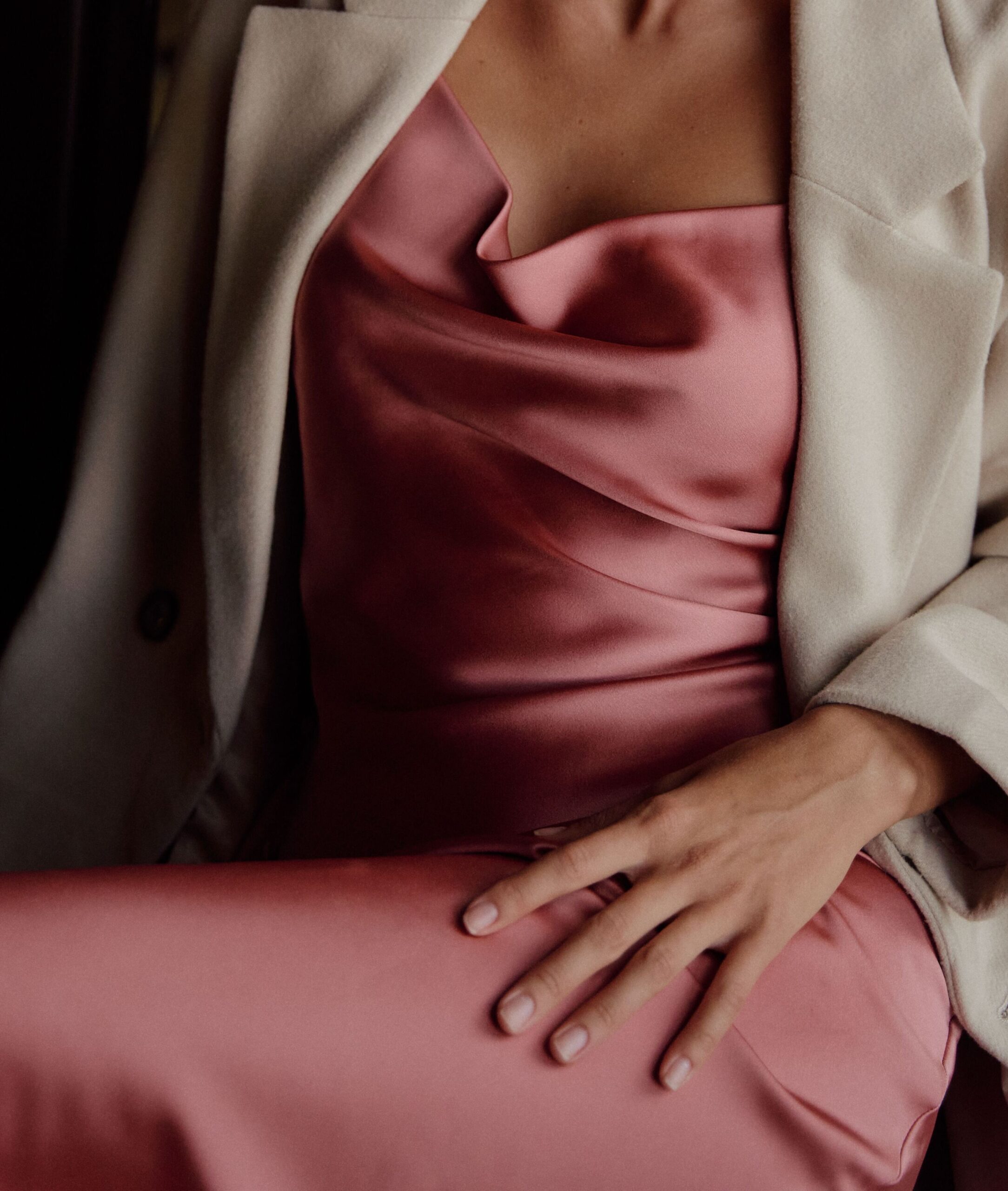 Détail d’une robe satinée rose, matière qui incarne une allure assumée