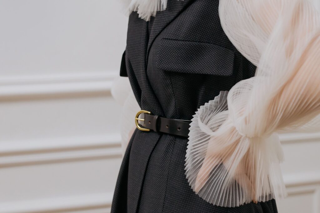 Détail de couture et ceinture sur un tailleur noir, illustrant la construction et la cohérence d'une garde-robe