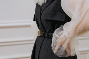 Détail de couture et ceinture sur un tailleur noir, illustrant la construction et la cohérence d'une garde-robe